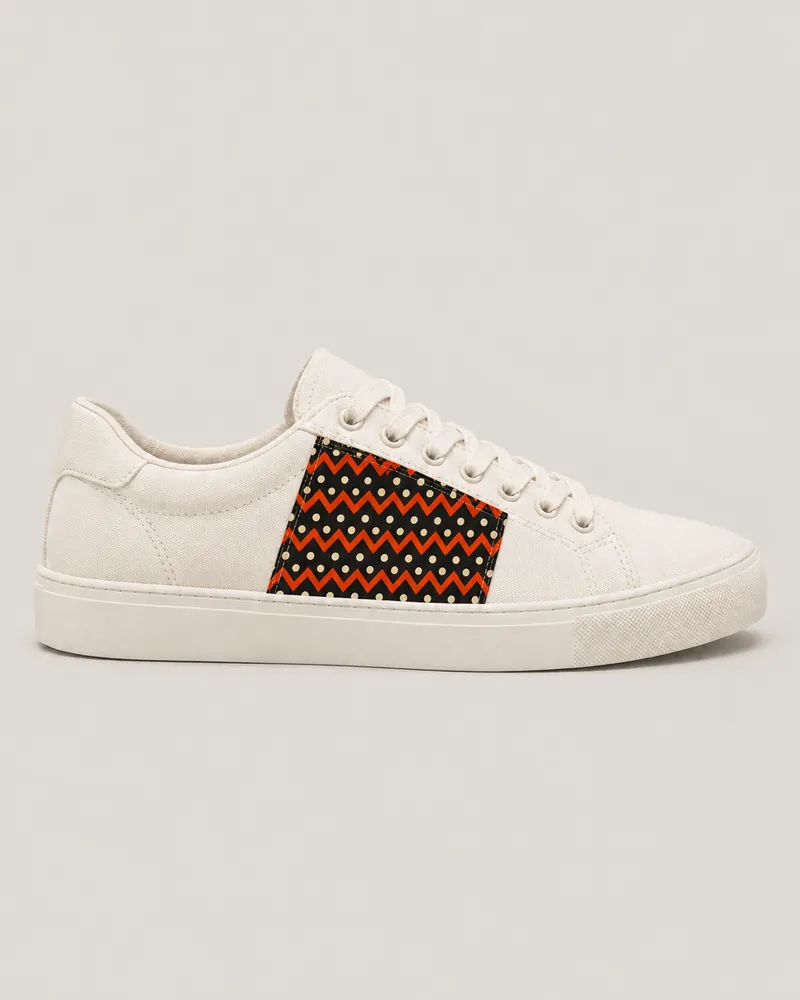 Ivory low-top sneaker with a sewn wax side panel, toe pointing right. AI-generated product concept.
